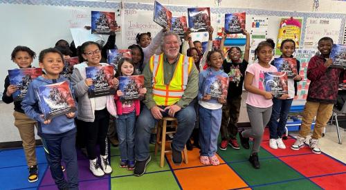 Chris Eccleston and a group of elementary school students holding his book
