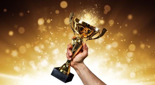 Man holding up a gold trophy cup