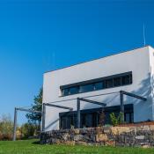 Modern, white, cube, elegant, minimalist style passive house with large panoramic windows, grey shutters in maintained garden