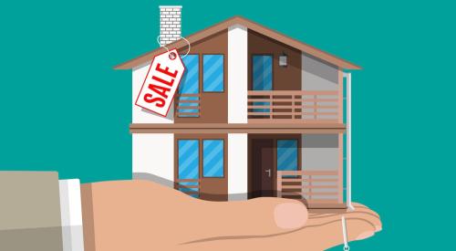 Hand holding house with price tag on it