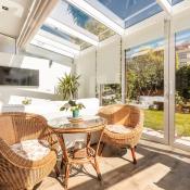Sun room with large skylights and screen door looking out onto a landscaped backyard