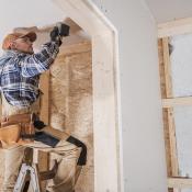 Worker on ladder works on dry wall