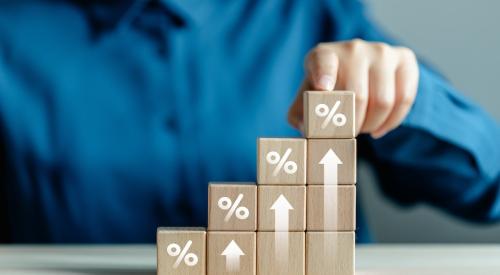 Wooden blocks showing percentage symbols and upward arrows, indicating rate increases