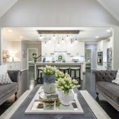 View of modern living room with newly remodeled kitchen in the background