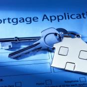 Mortgage application with house key on top of it