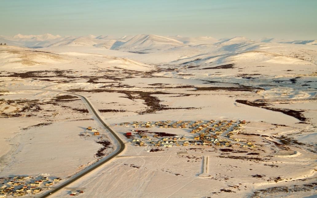 Aerial view of snow covered mountains and residential area on the outskirts of Nome, Alaska