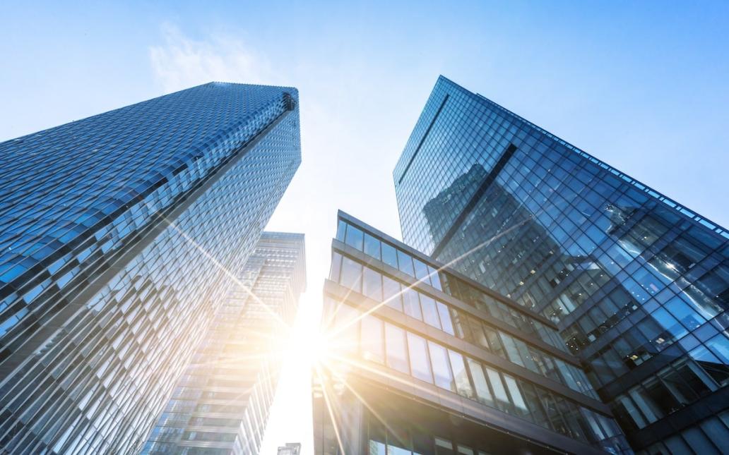 Upward view of skyscrapers against blue sky
