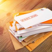 Pile of past due bills on wooden table