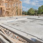 Exposed slab foundation with framed portion of home in background