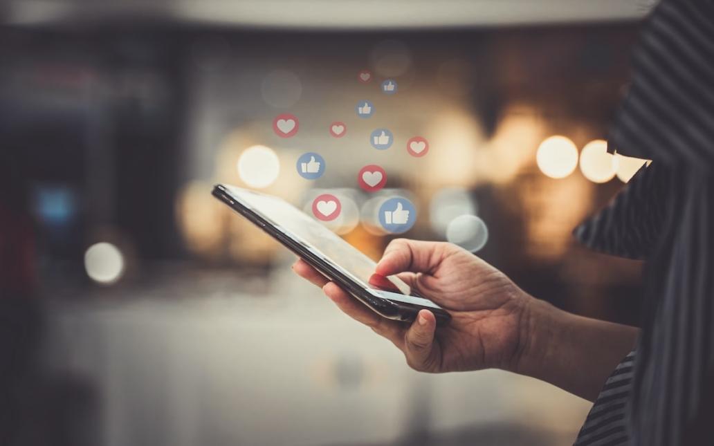 Close-up of hand using phone to post on social media