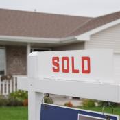 Home with "Sold" sign in front yard