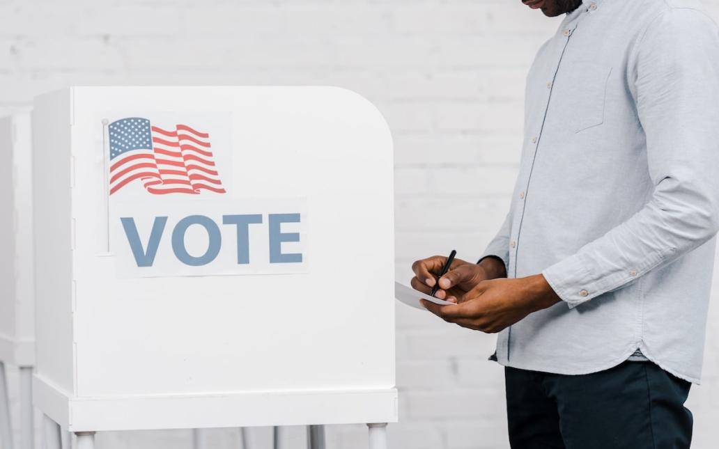 Voter approaches booth to fill out ballot