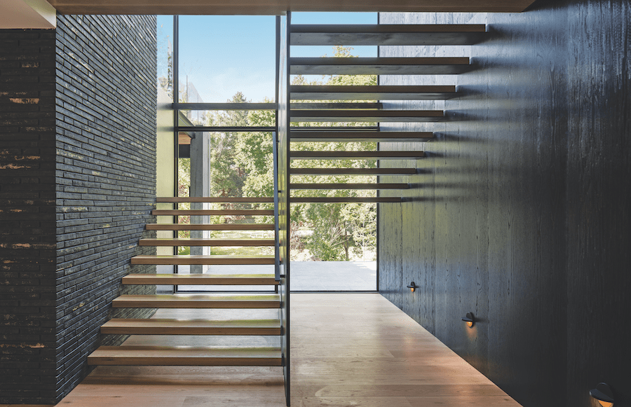 Shou sugi ban and dark brick walls in the staircase of the Burch Creek Home, a 2023 BALA winner
