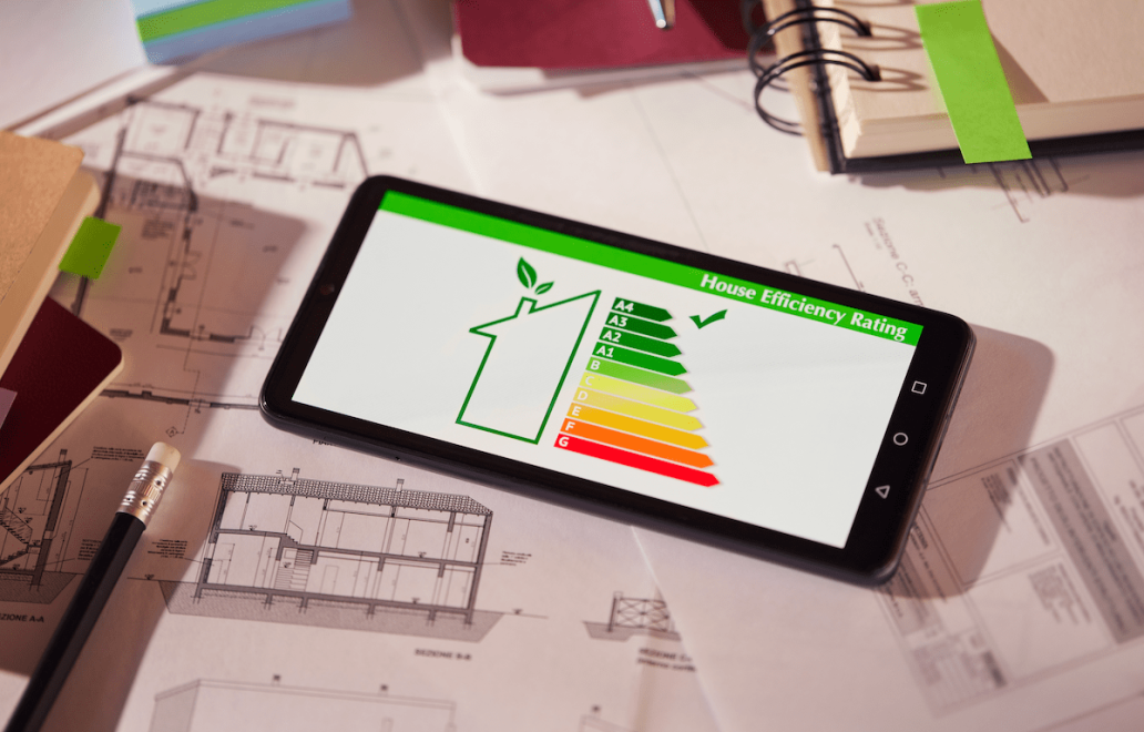 Energy-efficiency rating showing on tablet with house plans in background