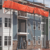 Netting installed with pump jack setup on jobsite for ladder safety