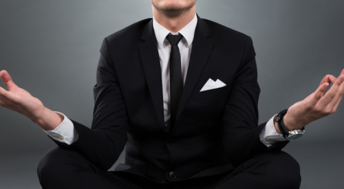 Businessman meditating in lotus pose
