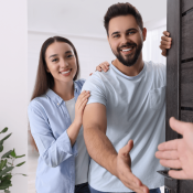 Young couple of renters welcoming as they open the door to their apartment